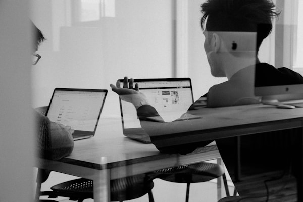 Small agency team reviewing workflow on laptop